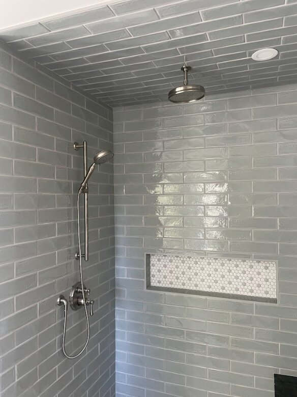 Shower before renovation with open framing and older materials