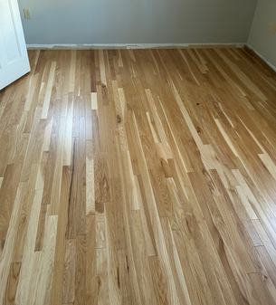 Newly installed natural hardwood flooring in a finished room